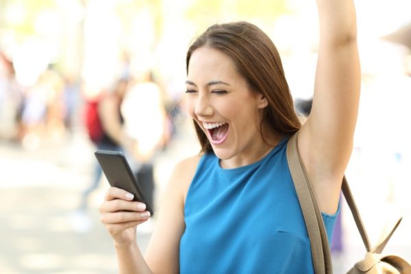 Excited woman receiving good news on phone